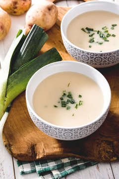 Shoot from above of two bowls of tasty Vichyssoise soups on wooden table with leek