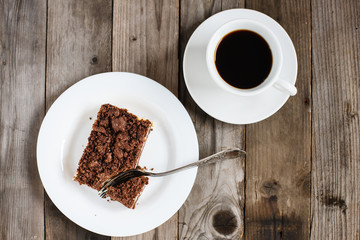 Kaffeegedeck: Zupfkuchen auf weißem Teller mit Gabel, Kaffeetasse, Holztisch, Draufsicht