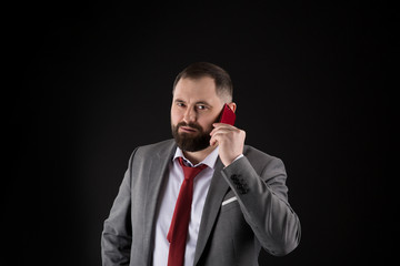 Guy call friend stand black background. Mobile call concept. Man formal suit call someone. Mobile call conversation. Mobile negotiations. Businessman well groomed mature man hold smartphone.