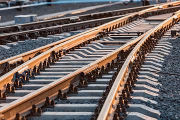 View of the rails, concrete sleepers and mound of crushed stone. The railroad tracks.