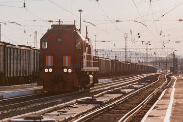 Fototapeta na wymiar The locomotive moves along the railway track at the station.