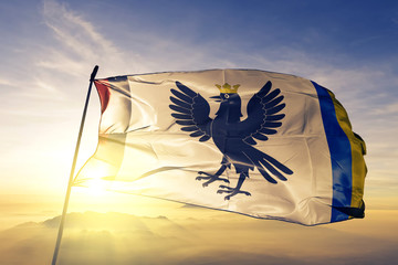 Ivano-Frankivsk oblast of Ukraine flag waving on the top sunrise mist fog
