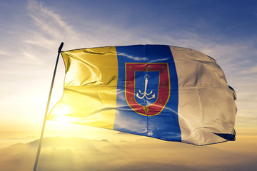 Odesa oblast of Ukraine flag waving on the top sunrise mist fog