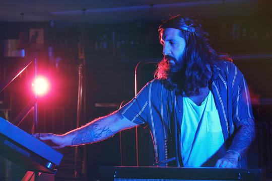 Bearded Dj man playing disco music in a club