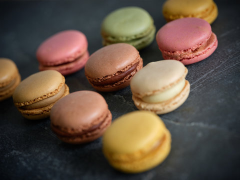 bright fresh tasty macaron biscuits on grey board