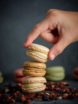 hand of anonymous person taking a macaron from a pile
