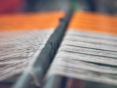 White and orange threads on loom