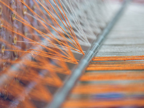 White and orange threads on loom