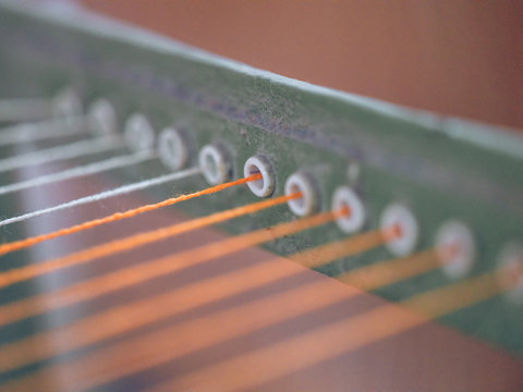 White and orange threads on loom