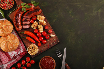 Grilled sausages with vegetables, spices and bread on wooden cutting board background. Top view