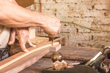 carpenter cutting plank with saw