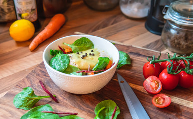 Salad bowl of vegetables, beans and piece of chicken in the kitchen for preparing the veggie meal.