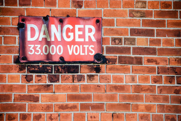 Obraz premium Warning sign outside an electricity substation saying 