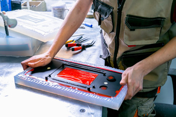 A worker extract the plastic detail from the mold. Manufacturing of plastic products. Medium...