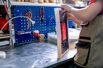 A worker extract the plastic detail from the mold. Manufacturing of plastic products. Medium business concept. Hands close-up