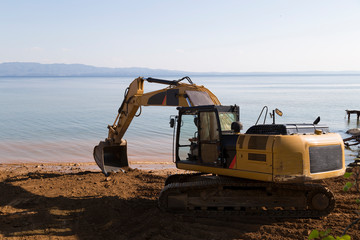 demolition of a hot dog stand at the beach. Hydraulic Crawler Excavator Cat working at a ground