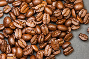 Freshly ground coffee beans roasted with fruits of coffee plant, on black background.