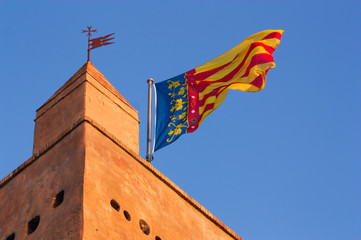 Flag of the Comunitat Valenciana atop a historic building
