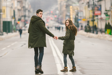 young couple, heterosexual boy and girl of Caucasian nationality, loving couple, walk around the center of country of European city in the middle of road on divided lane. Love and Romance Theme