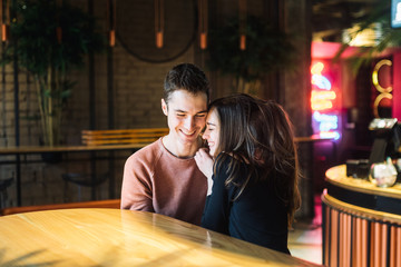 Theme love and holiday Valentines Day. couple of college students together in Caucasian heterosexual lovers winter inside the cafe sit at empty table embrace. Emotion happiness and love