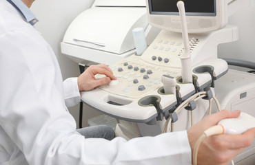 Sonographer operating modern ultrasound machine in clinic, closeup