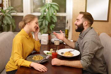 Fototapeta na wymiar Lovely young couple having pasta carbonara for dinner at restaurant