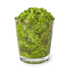 Glass of tasty pesto sauce isolated on white