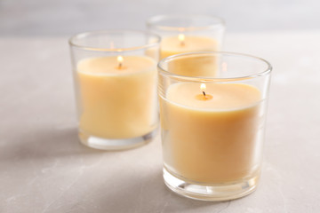 Three burning candles in glasses on table
