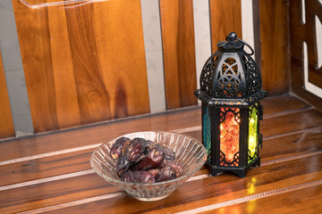 Islamic decorative or ornaments, lantern and dates, kurma isolated on shine wooden background, iftar preparation, fasting in Ramadan concept. Selective focus.
