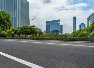empty asphalt road near glass office building.