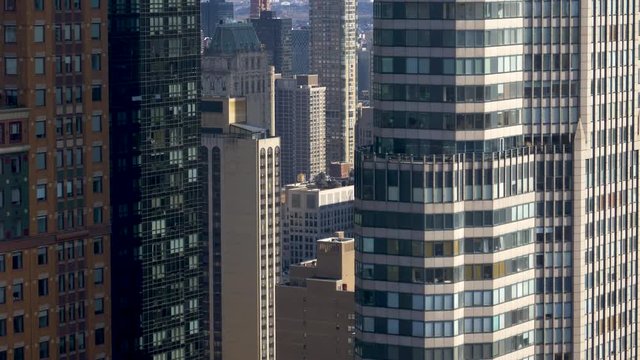CLOSE UP: Breathtaking view from above of the glassy skyscrapers in sunny NYC at daytime in autumn. Stunning view of the modern high rise architecture in the business district on Manhattan Island.