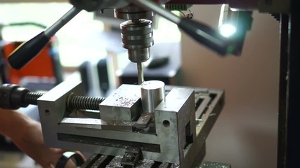 Milling machine smooths surfaces on aluminum cylinder.Setting up and milling a metal cylinder on a drilling machine.