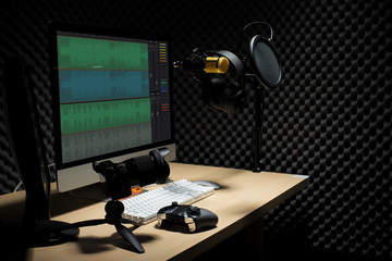 Microphone Condenser, gold mic hang over sound absorbing wall room with wave monitor keyboard mouse...