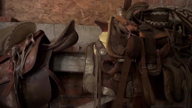 mexican horse-riding saddles in a rustic warehouse