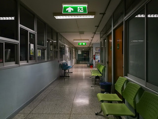 Green emergency exit sign in hospital showing the way to escape at night