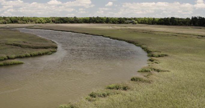 Aerial drone flying over big bend in river water above marsh grass. 4k footage above coastal waterways of south Georgia.