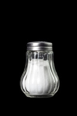 glass salt shaker with metal cap isolated on black background