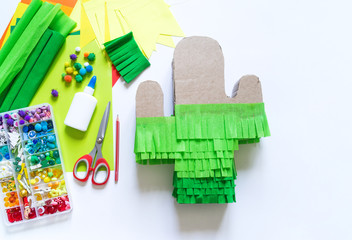 Diy cinco de mayo Mexican Pinata cactus made cardboard and crepe paper your own hands on a white background. © Дарья Колпакова
