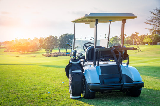 Golf cart park on green grass in golf course ,beautiful view of golf course and sun sky background