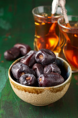 Large Medjool Dates in a bowl and two cup of tea. Ramadan kareem