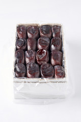 Large Medjool Dates in a cardboard packing. Closeup view of top