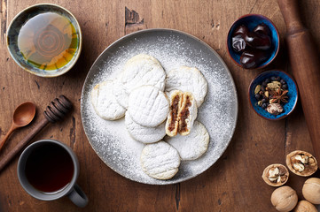 Arabic homemade cookies filled with dates and walnuts covered powdered sugar