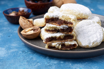 Fototapeta na wymiar Arabic homemade cookies filled with dates and walnuts covered powdered sugar