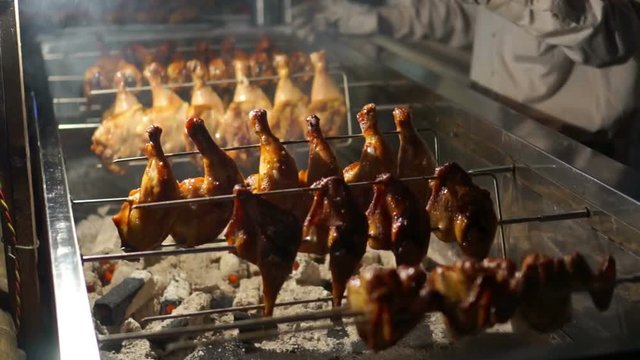 Street vendor sells rotisserie duck in Shanghai.Chinese food cart on the road selling spit roasted meat.