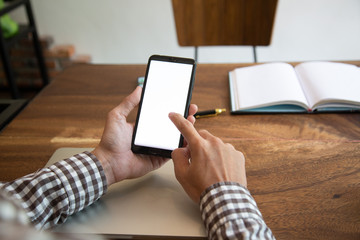 businessman hands searching for data on mock up mobile phone with at his workplace.concept