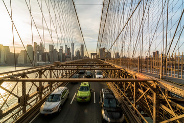 Fototapeta premium Traffic in rush hour after working day on the Brooklyn bridge over New York cityscape background with sunset, USA, United States, Business and transportation concept