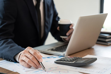 Fototapeta premium strategy analysis concept, Businessman working financial Manager Researching Process accounting calculate analyse market graph data stock information review on the table in office.