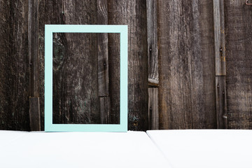turquoise blue empty picture frame on white wood table, old wooden background