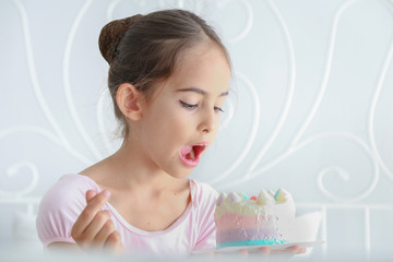 Obraz na płótnie Canvas Cute little child girl in pink dress was eating birthday cake. 