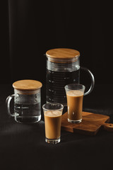 Water bottles and milk coffee glass on dark background.